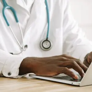 A doctor working with her laptop sitting at a table.