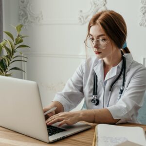 A doctor working her laptop sitting at a table.
